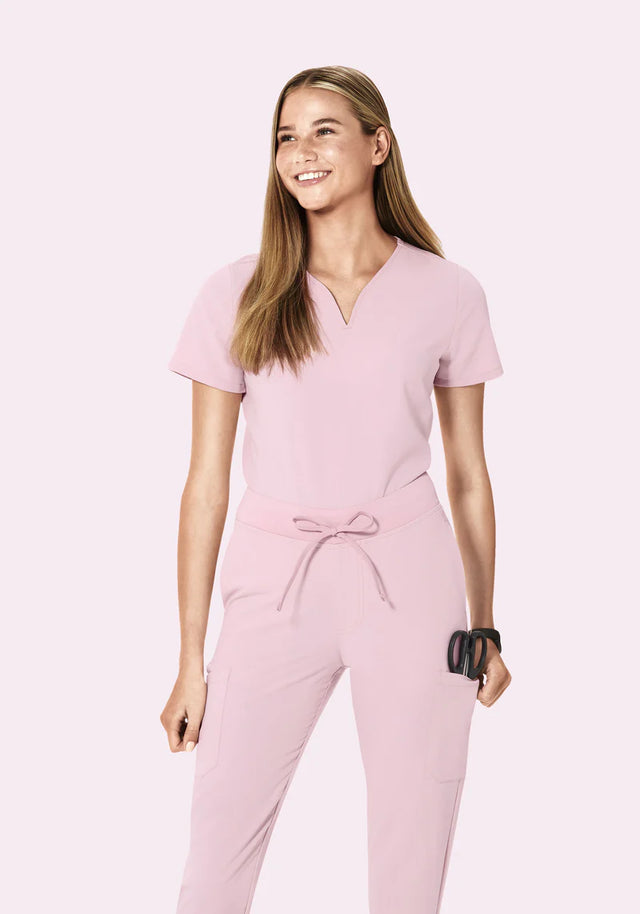 Woman wearing a pink jumpsuit on a light pink background