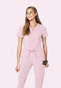 Woman wearing a pink jumpsuit on a light pink background